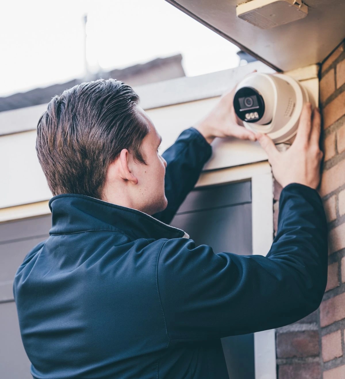 Jacco Jan Eefting installeert een Hikvision beveiligingscamera bij een voordeur